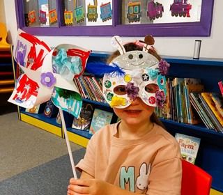 Child with painted windmill and mask