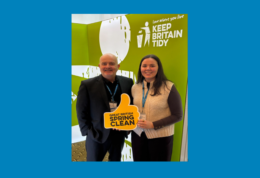 Two people standing holding sign