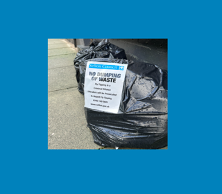 Bags of rubbish with sign to not fly-tip 